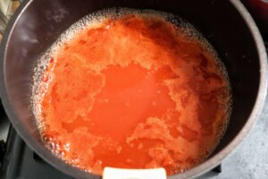 お鍋にトマト缶、水を入れて煮立たせる