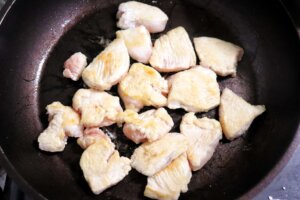 フライパンにごま油を入れて熱し、鶏胸肉の色が変わるまで炒める