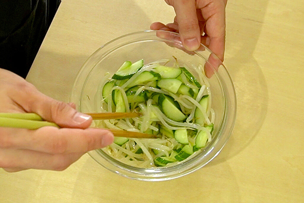 もやしときゅうりにごま油を絡める