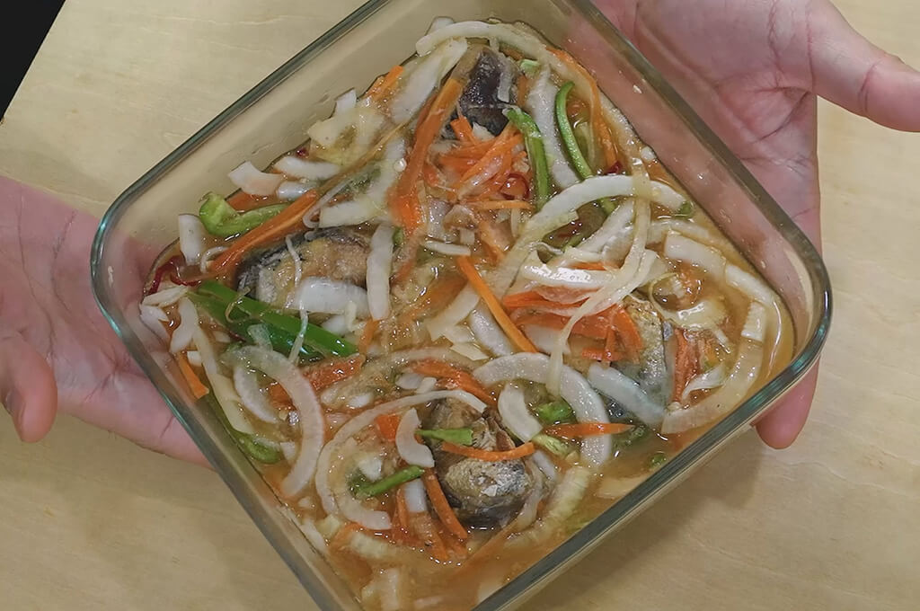 焼いたサバの身を保存容器に加えて漬ける