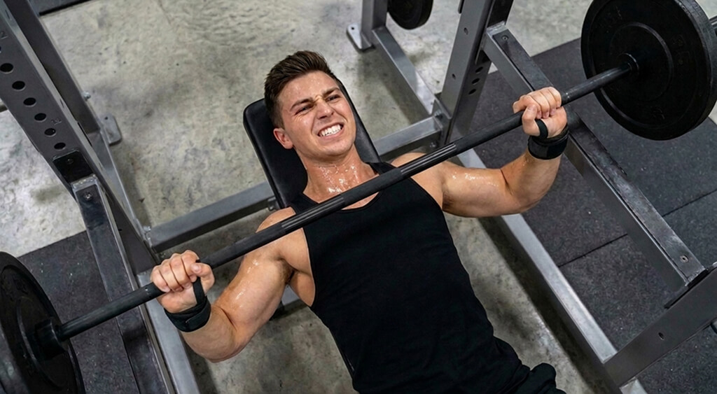 リストラップを巻いてベンチプレスをしている男性