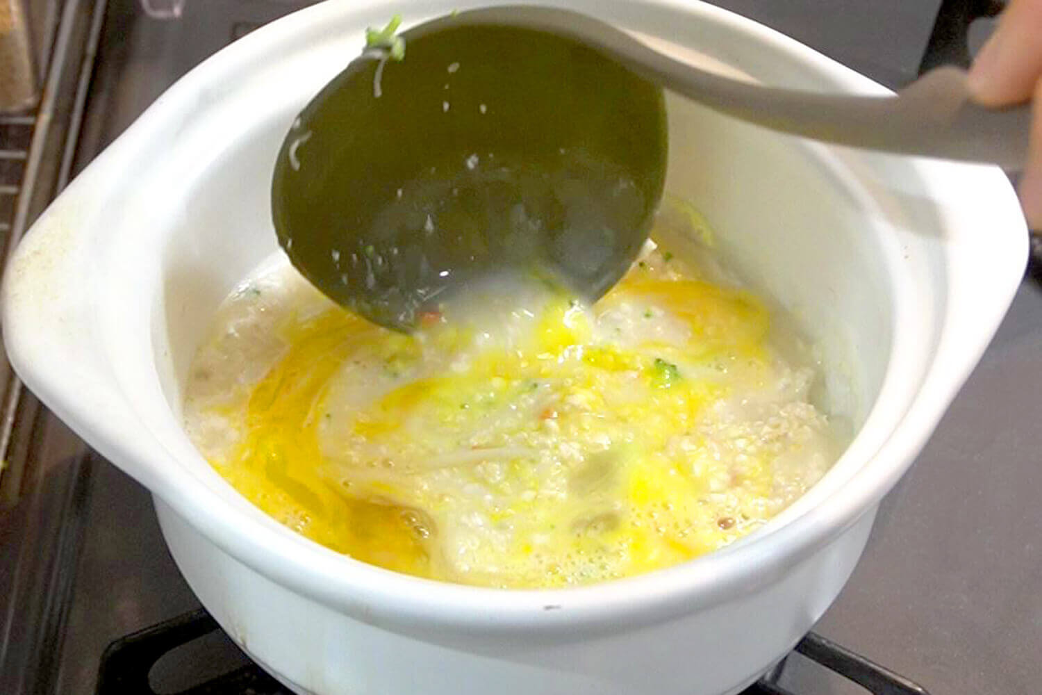 カニカマをほぐし水を加え、煮立たせてオートミール、溶き卵を加える